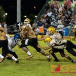 JFK Islander's Deante Delgado drives the ball forward in the IIAAG high school football game against the Tiyan High Titans. (Photo by Michael Blas)