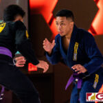 Peter Benevente (black) finishes his opponent Don Rasa (blue) near the midway point of the Purple Belt Bout. (Photo by Michael Blas)