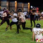 JFK Islander Jacobe Quinata breaks through the FD defensive line for the first down. (Photo by Michael Blas)