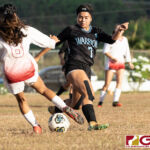 St. John's Knights Yasmeen Lopez goes in for the kick as Warriors Tiffani Lopez defends. (Photo by Michael Blas)