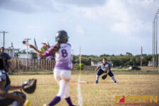 Academy Cougars Olivia Salas looks on as GW Geckos Savannah Grant swings at bat. ( photo by Bout It Productions )