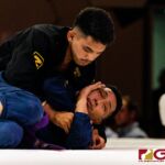 Peter Benevente (black) finishes his opponent Don Rasa (blue) near the midway point of the Purple Belt Bout. (Photo by Michael Blas)