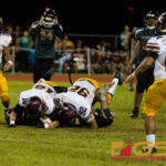Player of the Game Kobe Onedera, number 92, and number 18 Evan Brown flattens out JFK's RB. (Photo By Michael Blas)