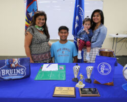 The Hennegan family poses for a photo after Micah Hennegan, center in light blue T-shirt, officially signed to play for Bob Jones University during a three-part signing event Saturday at the Guam Football Association National Training Center Lecture Hall. In the photo are, from left to right, Marilyn Hennegan, Micah Hennegan, and Mariah Hennegan, holding Camila Hennegan.